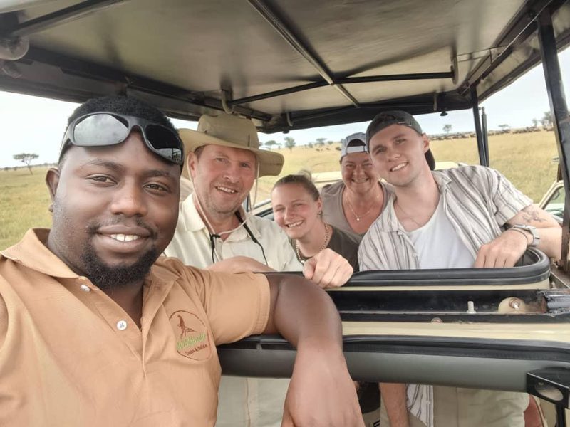 Guide and a group of guests laughing in the safari vehicle