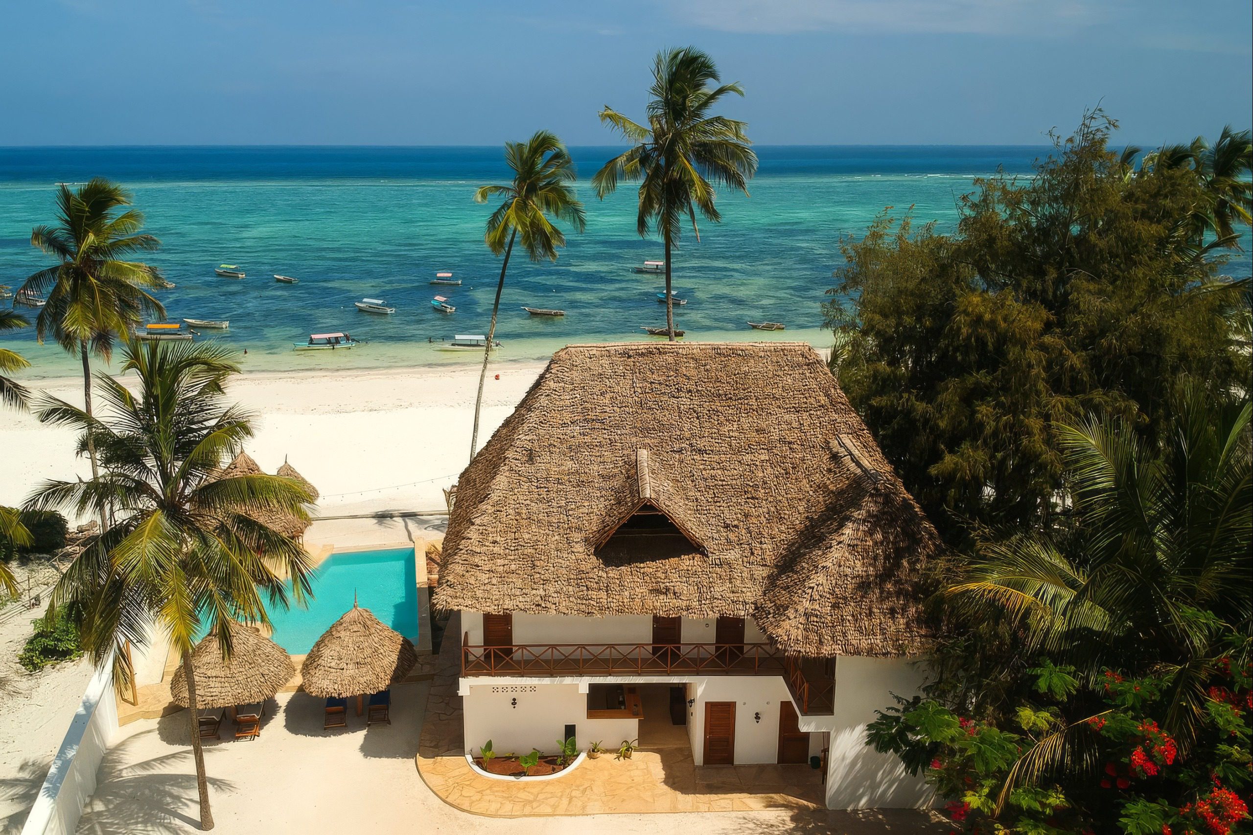 Strand mit Palmen und Booten am Alladin Beach Hotel and SPA Zanzibar