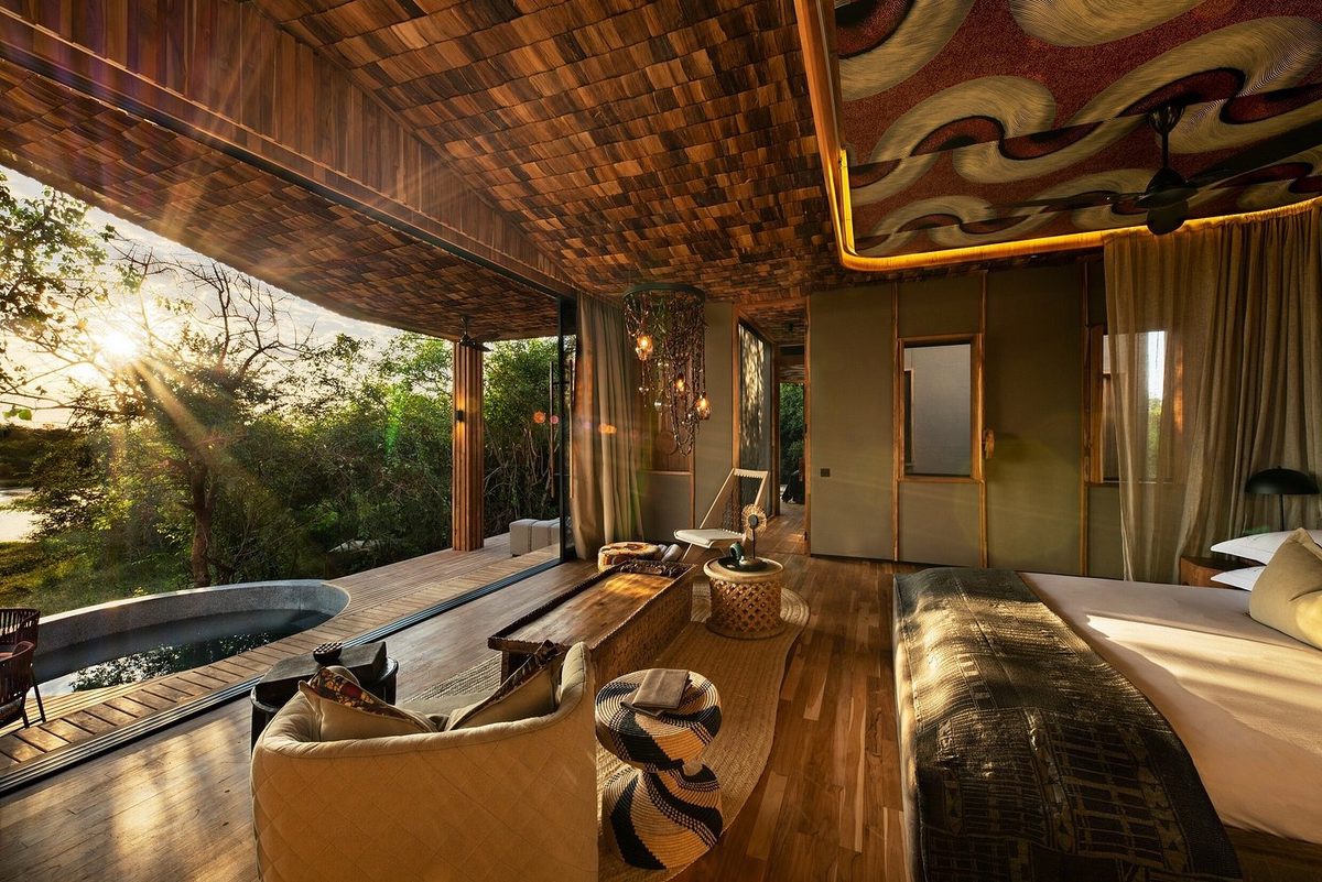 Zimmer mit Wanne, Bett und Holzdeck im Abendlicht