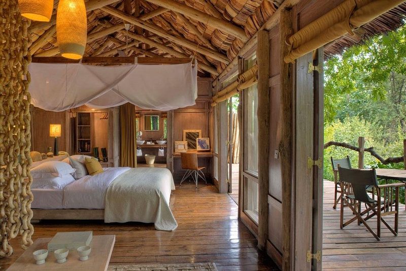 Zimmer mit Bett unter Moskitonetz und angrenzendem Bad