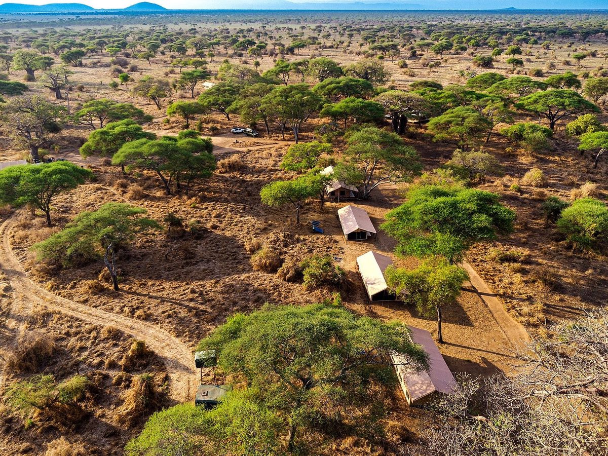 Zeltlager in trockener Savannenlandschaft aus der Luft