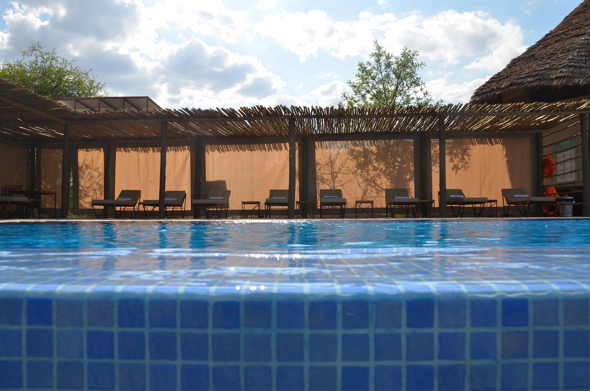 Pool, gesehen durch eine Holzpergola am Lake Burunge