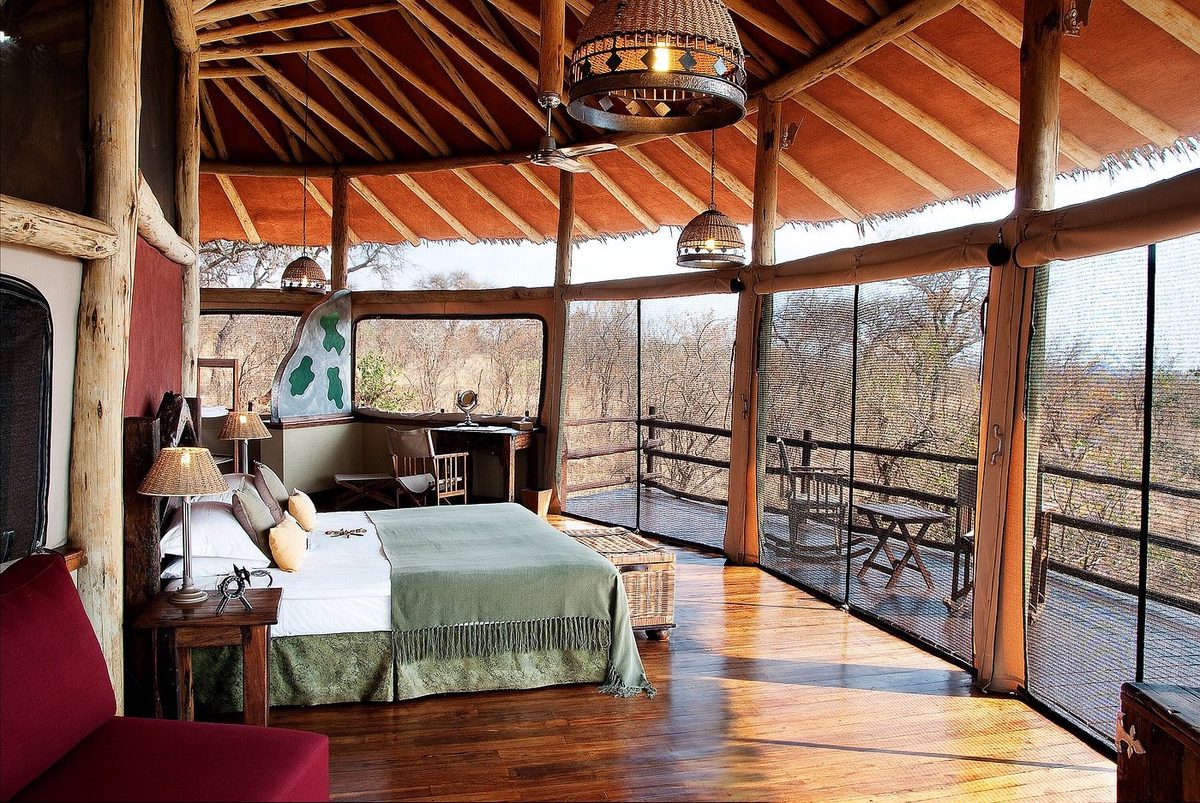 Tienda bajo techo de paja con cama y terraza