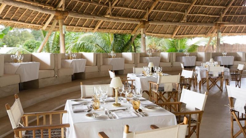 Restaurant unter Strohdach mit gedeckten Tischen