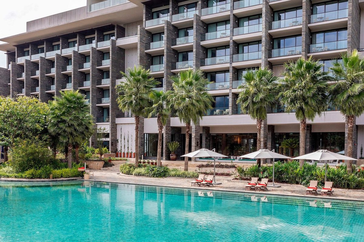 Hotelgebäude mit Pool und Palmen in Arusha