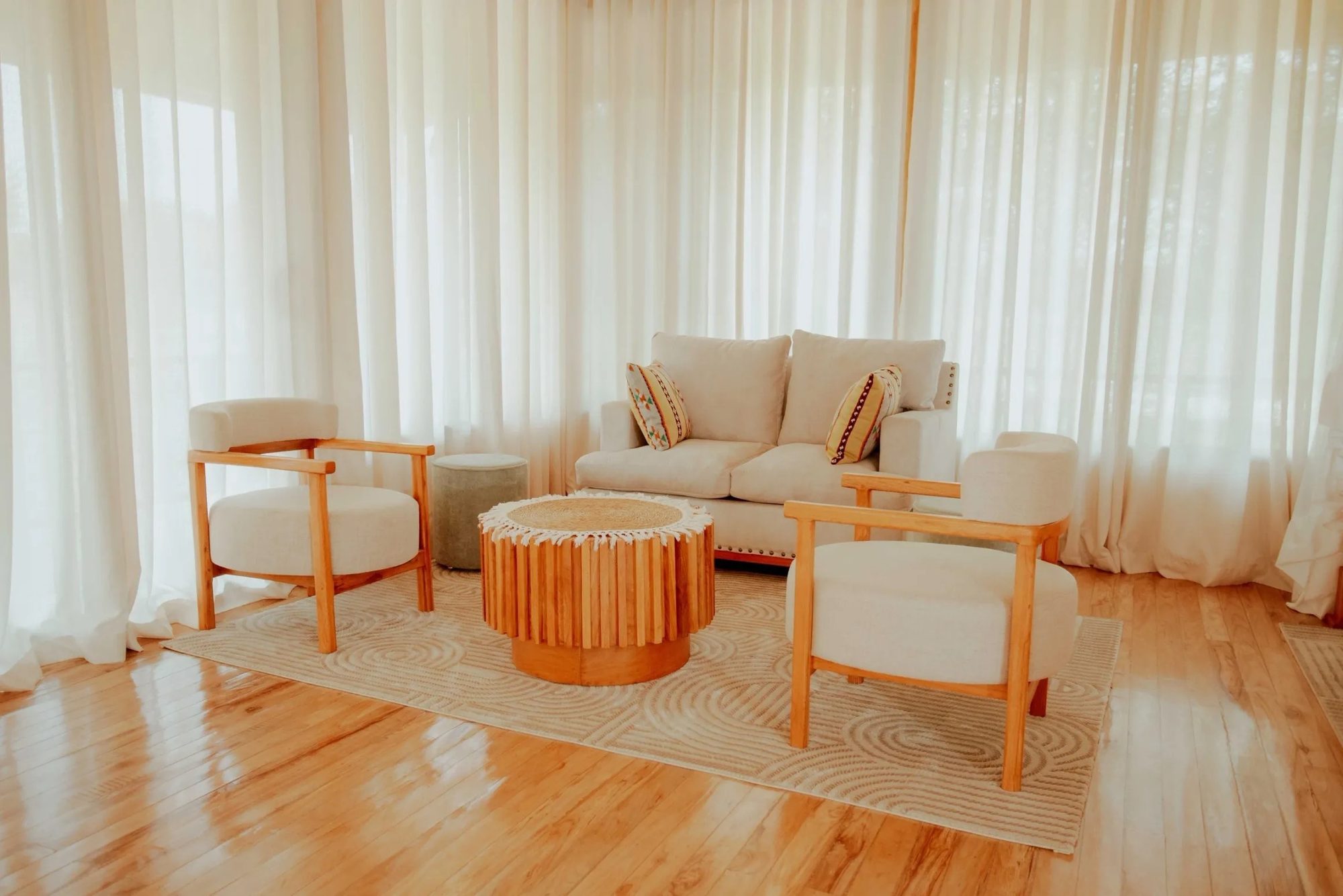 Lounge mit hellen Sitzmöbeln und Holzboden