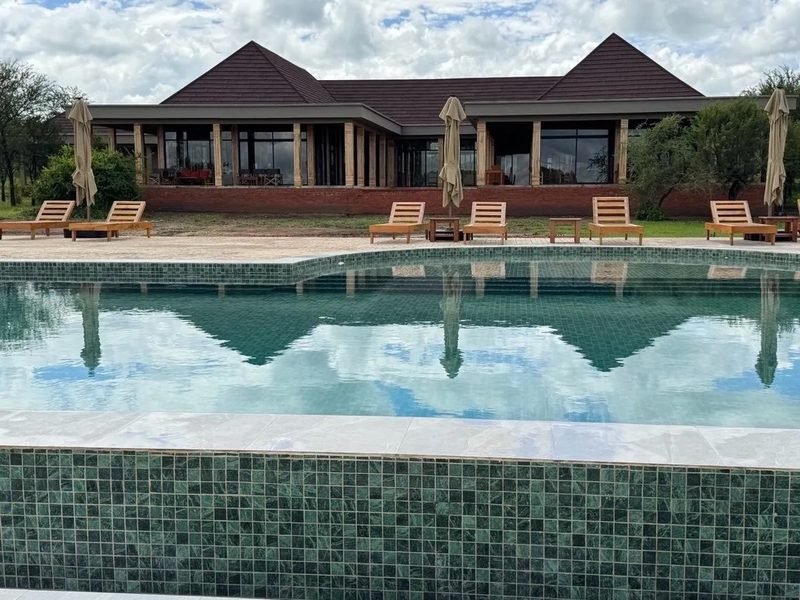 Pool mit Liegen und angrenzendem Gebäude