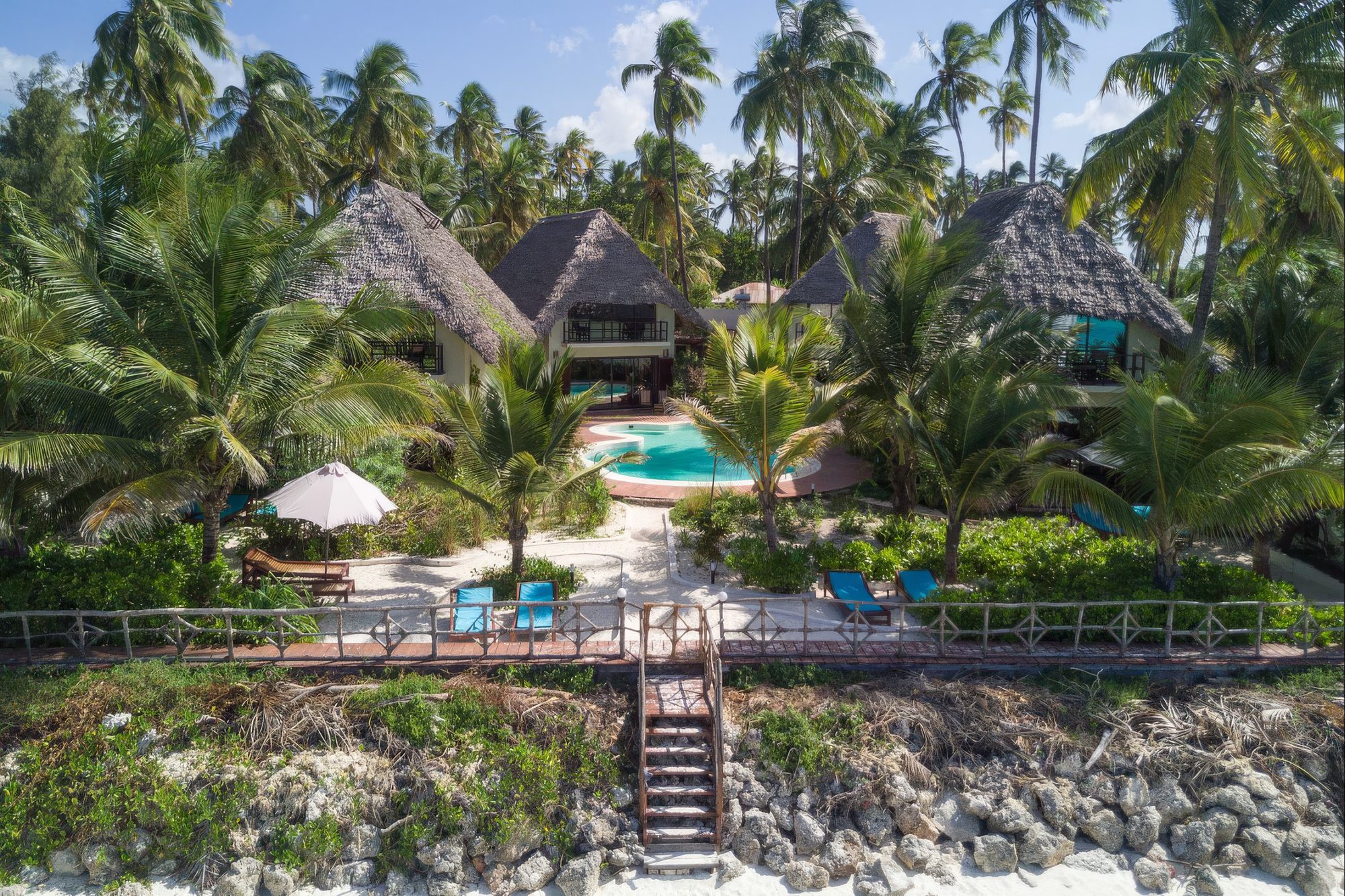 Vista aérea del complejo de villas de Jambiani Villas con piscina y palmeras