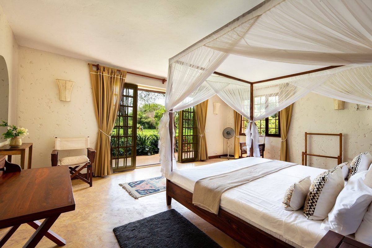 Schlafzimmer mit Baldachinbett und Zugang zur Terrasse