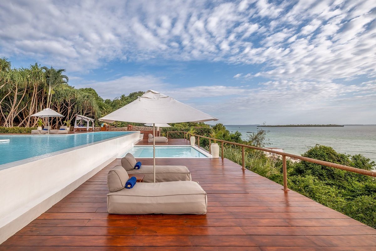 Pool-Terrasse mit Liegen und Blick aufs Meer