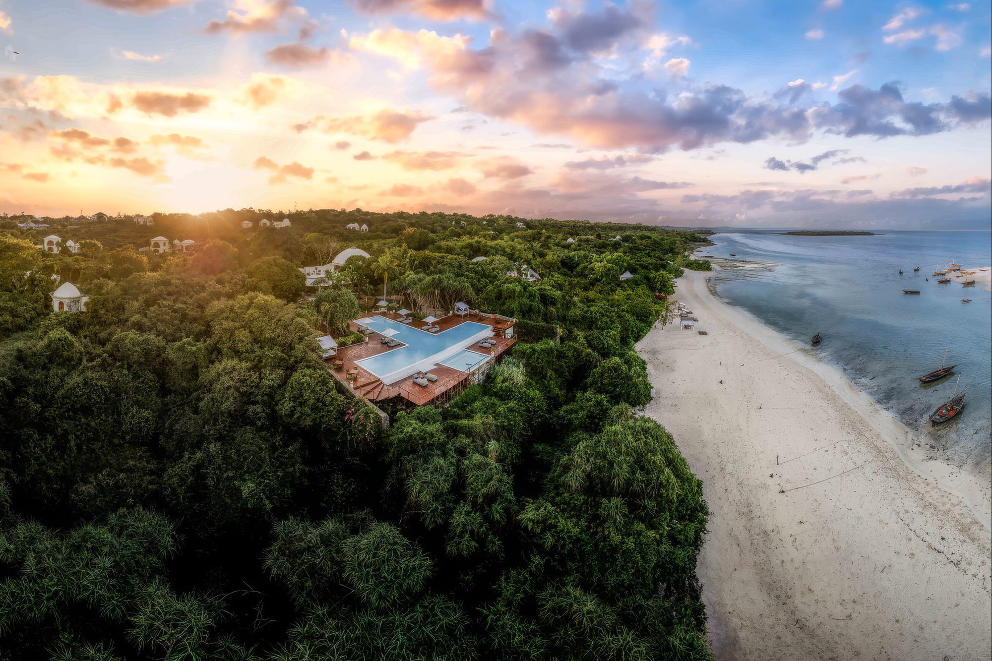 Complejo de Kilindi Zanzibar rodeado de vegetación en la playa a la puesta de sol