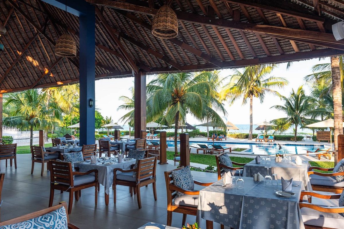 Comedor cubierto con mesas puestas y vistas al mar