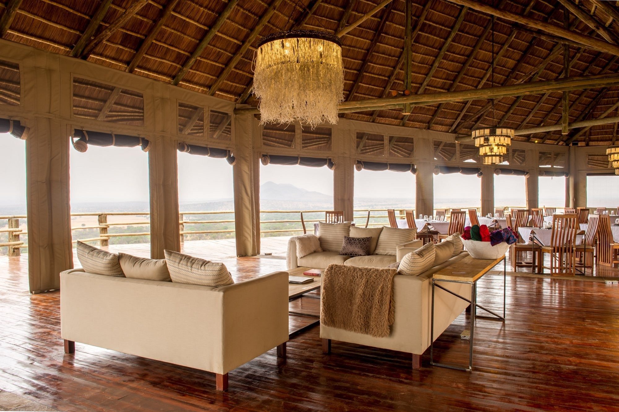 Lounge unter Strohdach mit Sitzmöbeln und Savannenblick