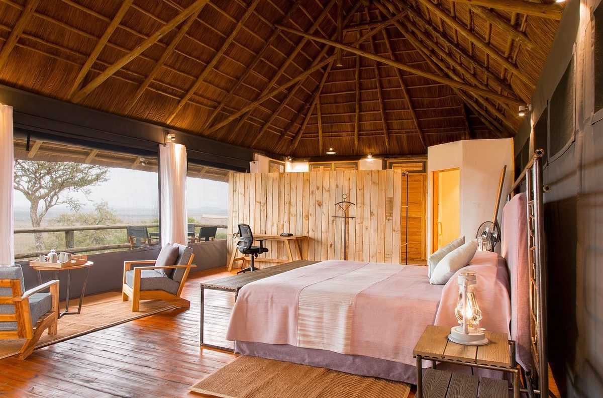 Zimmer mit Bett, Terrasse und Blick in die Savanne