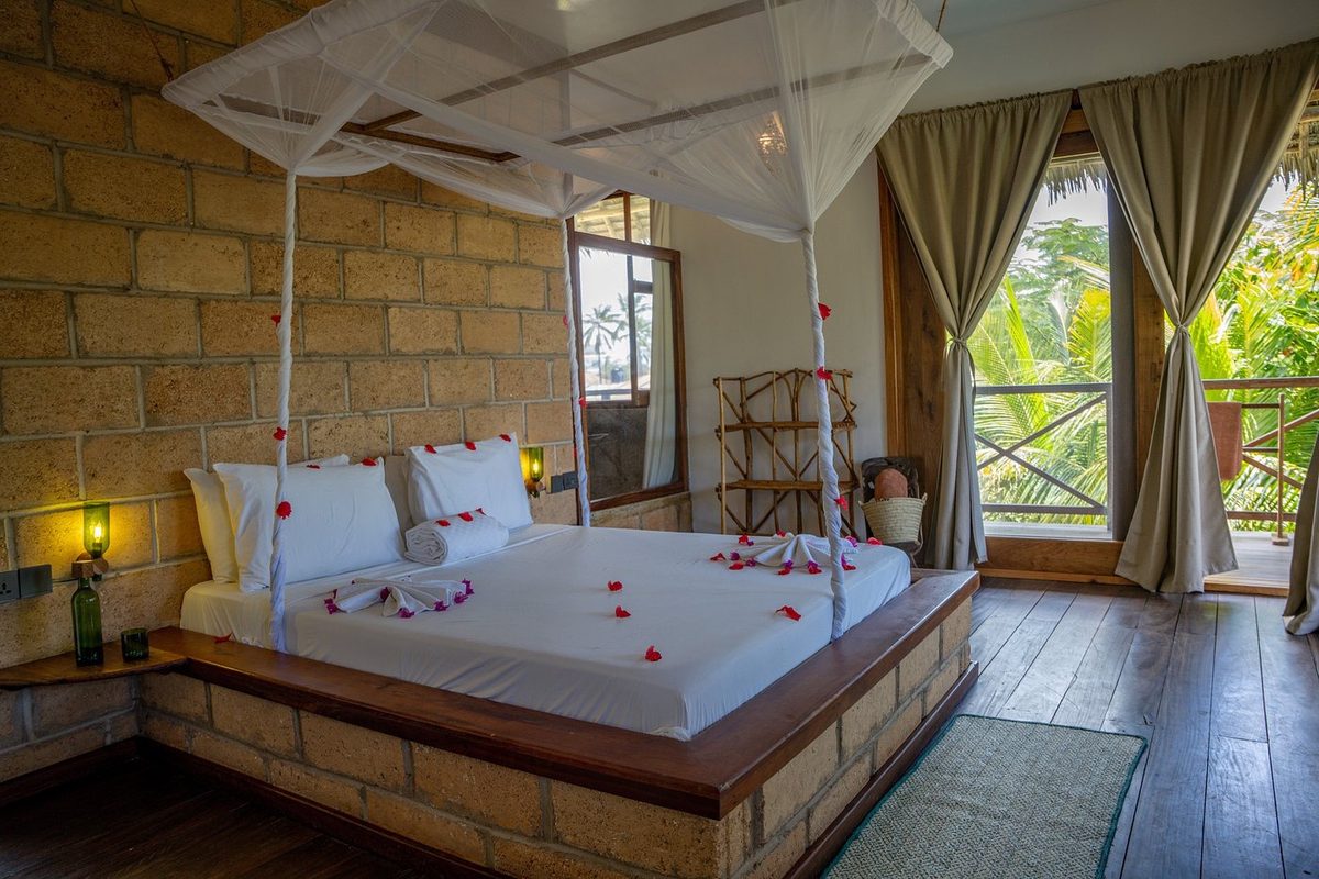 Habitación con pétalos de flores sobre la cama y acceso a la terraza
