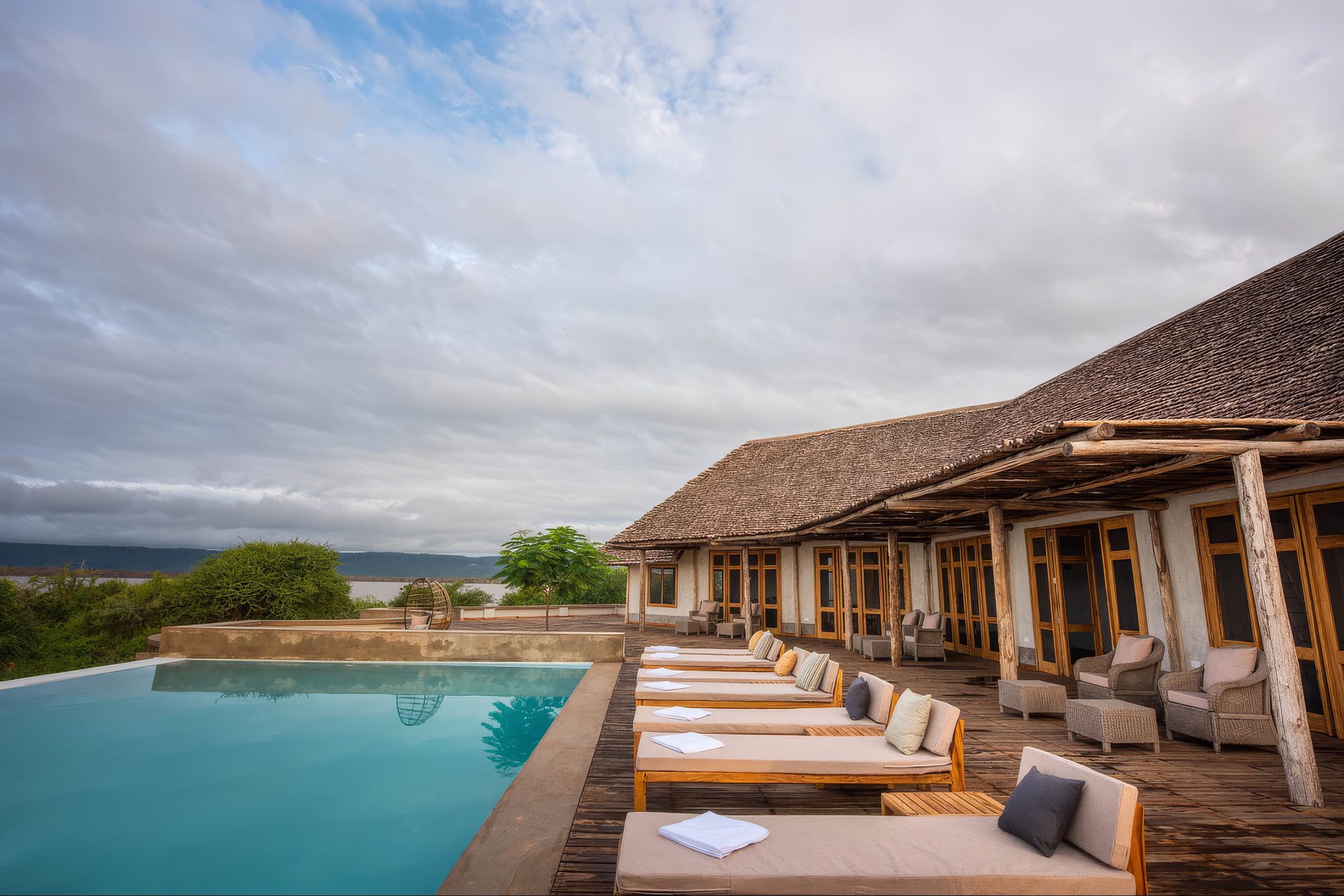 Pool terrace of Manyara's Secret with loungers and views of Lake Manyara
