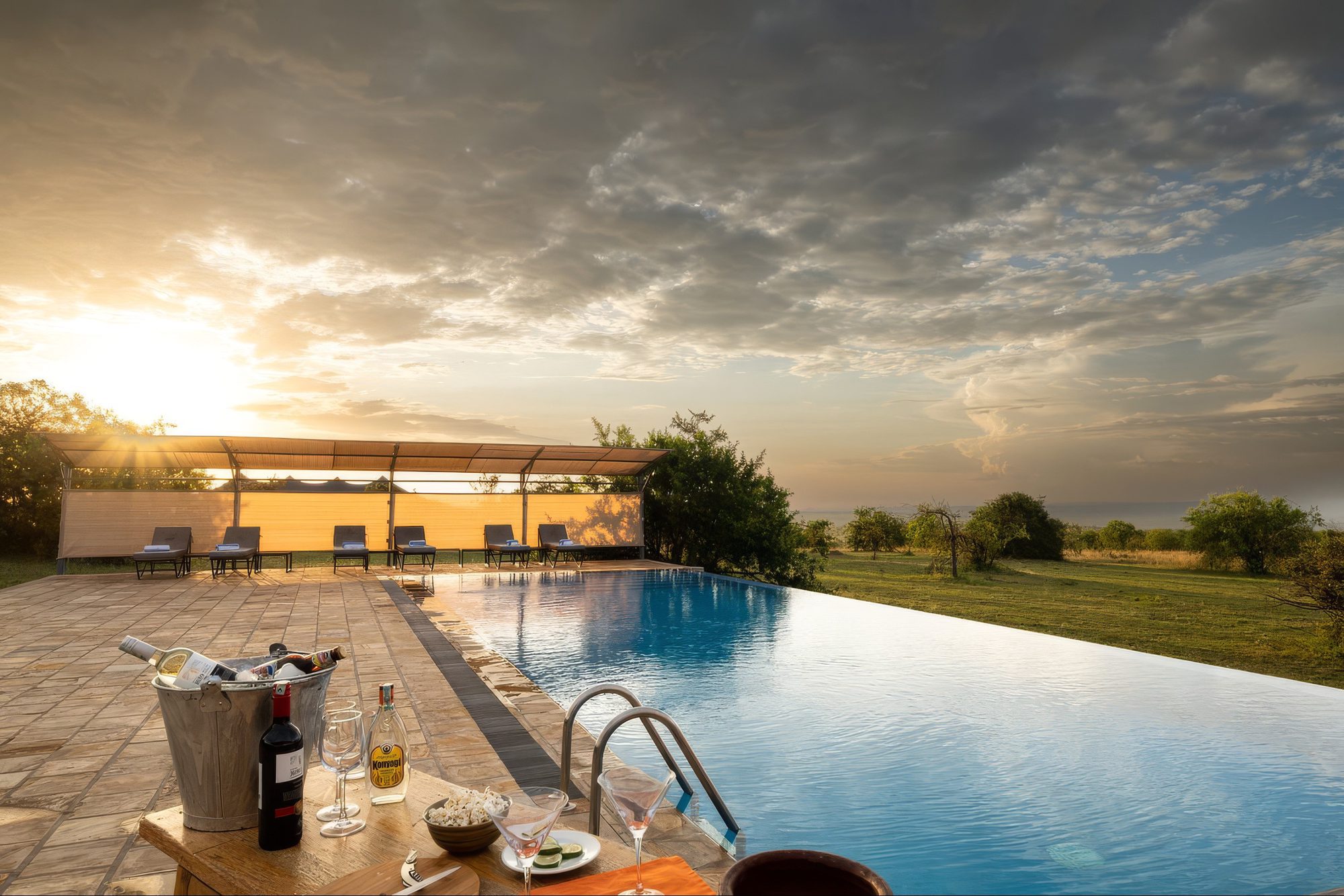 Pool terrace of Mara Mara Tented Lodge with drinks at sunset