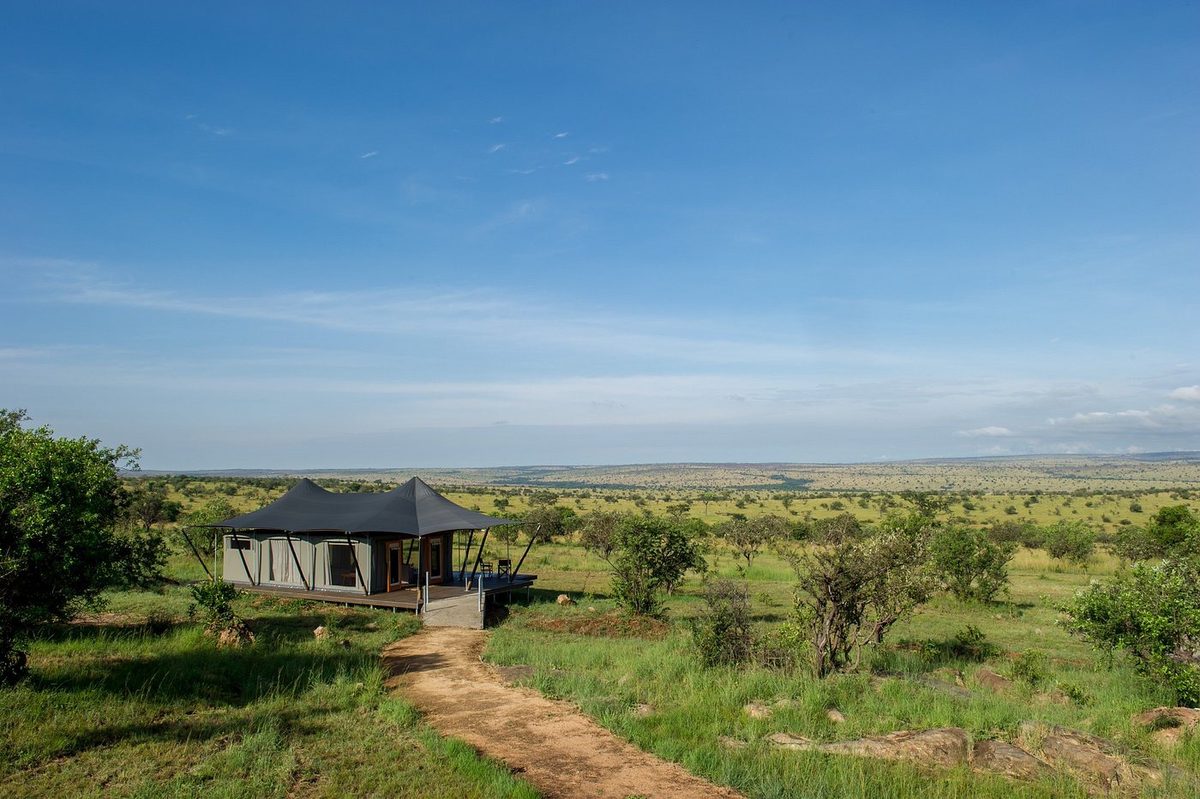 Tented bungalow in the wide savannah landscape of the Serengeti