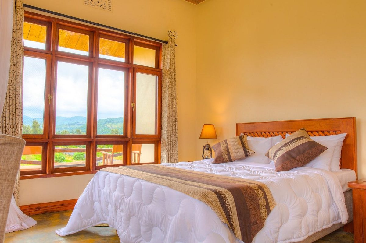 Habitación con cama, ventana panorámica y vistas al paisaje