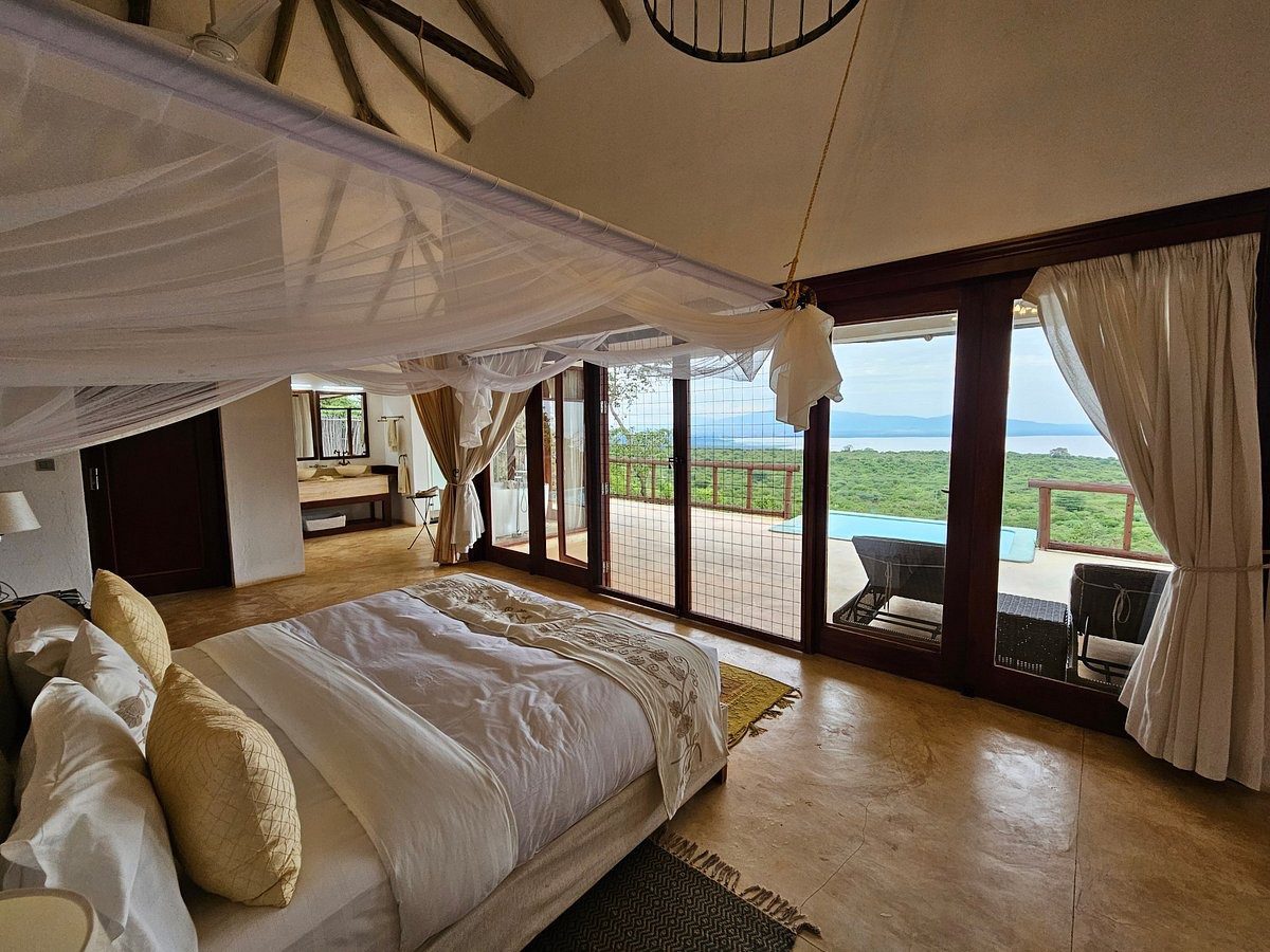 Zimmer mit Moskitonetz-Bett und Seeblick durchs Fenster