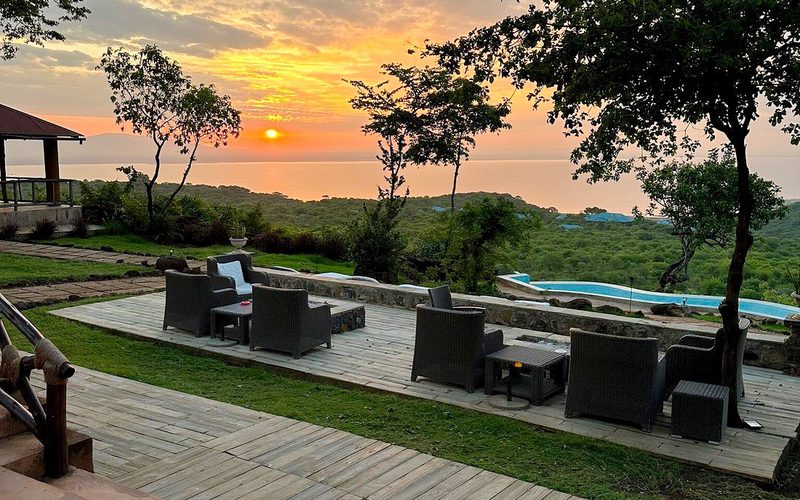Terrasse mit Sitzmöbeln und Seeblick bei Sonnenuntergang