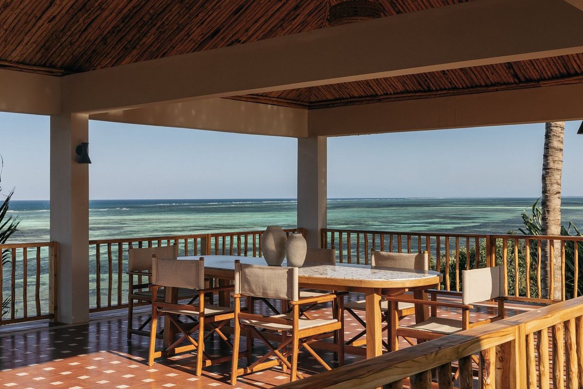 Überdachte Terrasse mit Esstisch und Meerblick
