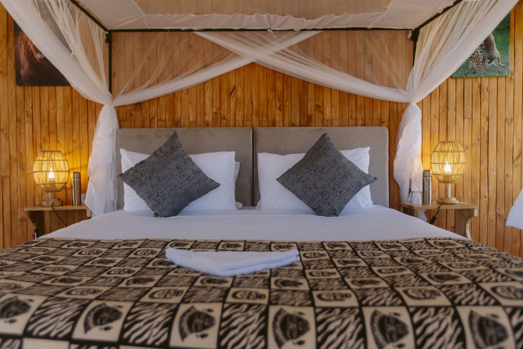 Interior of a tent room with four-poster bed in dark patterns