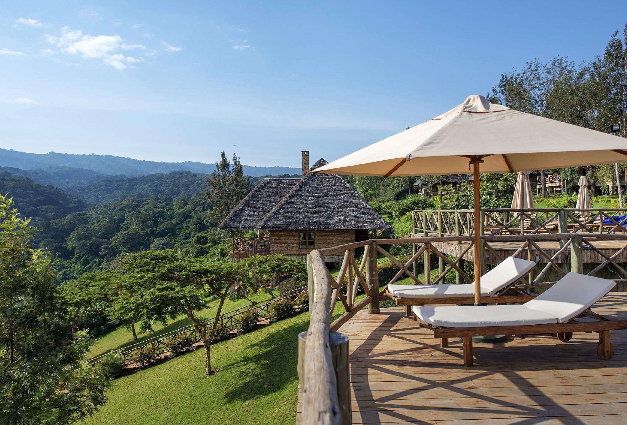 Terrasse der Neptune Ngorongoro Luxury Lodge mit Liegen über den Hügeln