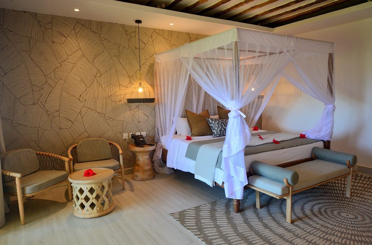 Habitación con cama bajo mosquitera y rincón de asientos