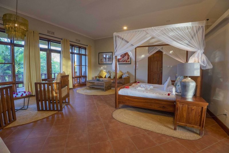 Interior de habitación con cama con dosel y rincón de asientos