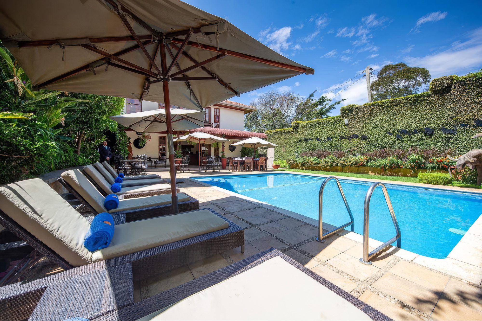 Pool-Terrasse von The African Tulip mit Liegen und Sonnenschirm