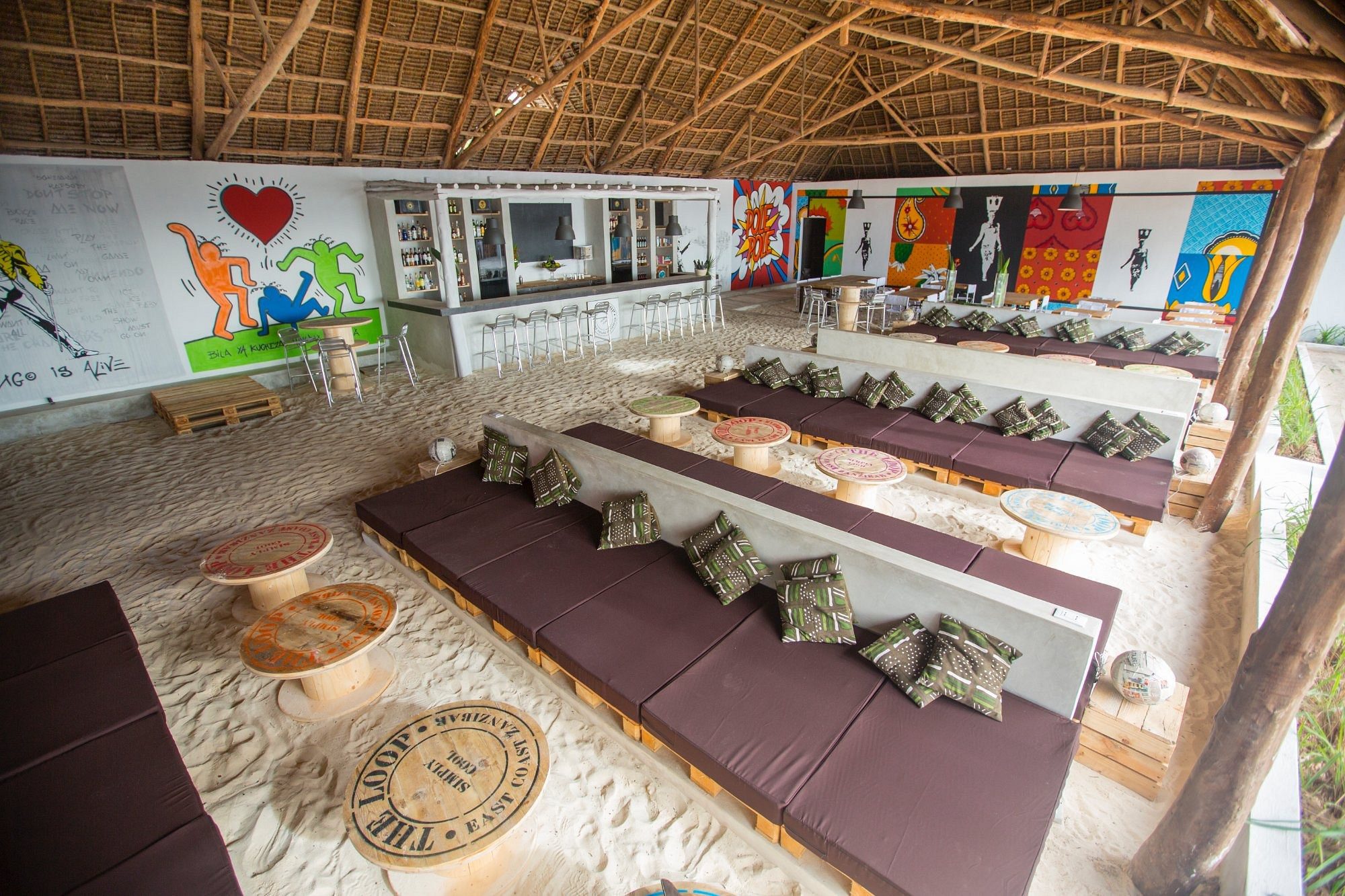 Zona de salón cubierta con murales y cojines de asiento
