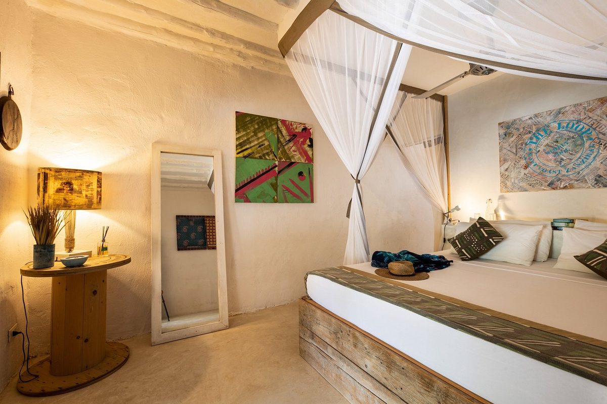 Habitación con cama y obras de arte en la pared