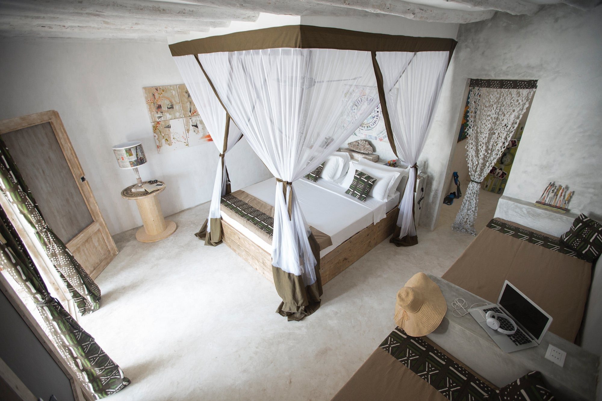 Habitación con cama con dosel y obras de arte coloridas