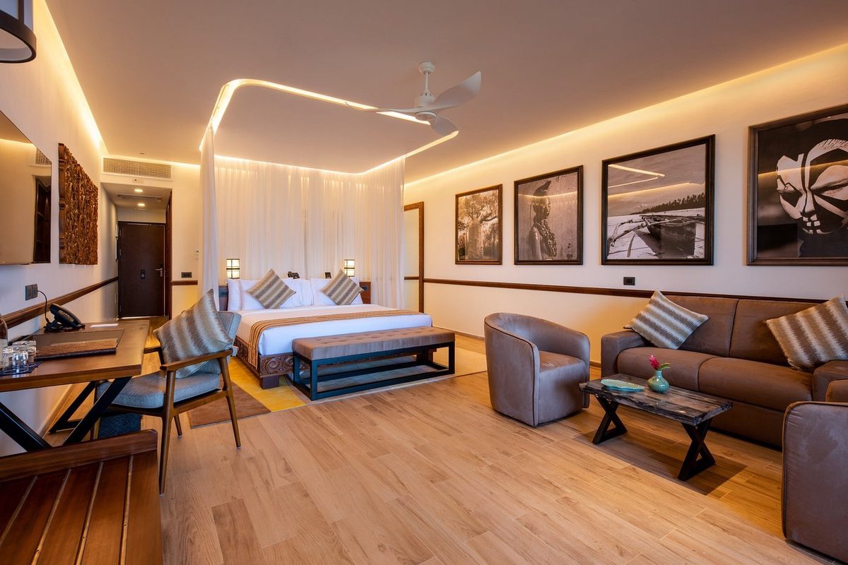 Zimmer mit Bett, Sitzmöbeln und Kunstwerken