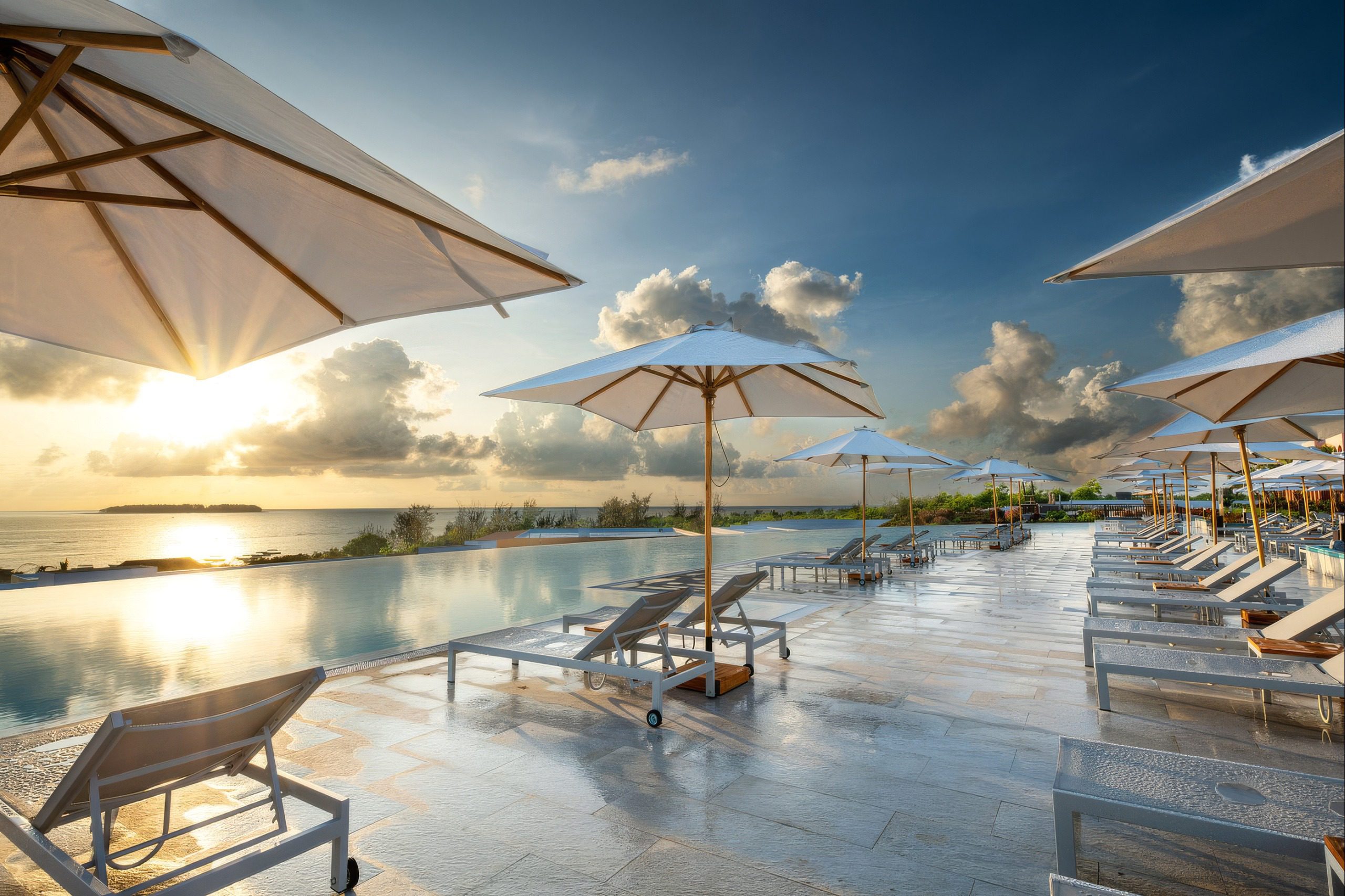 Pool-Terrasse von The Mora Zanzibar mit Sonnenschirmen bei Sonnenuntergang