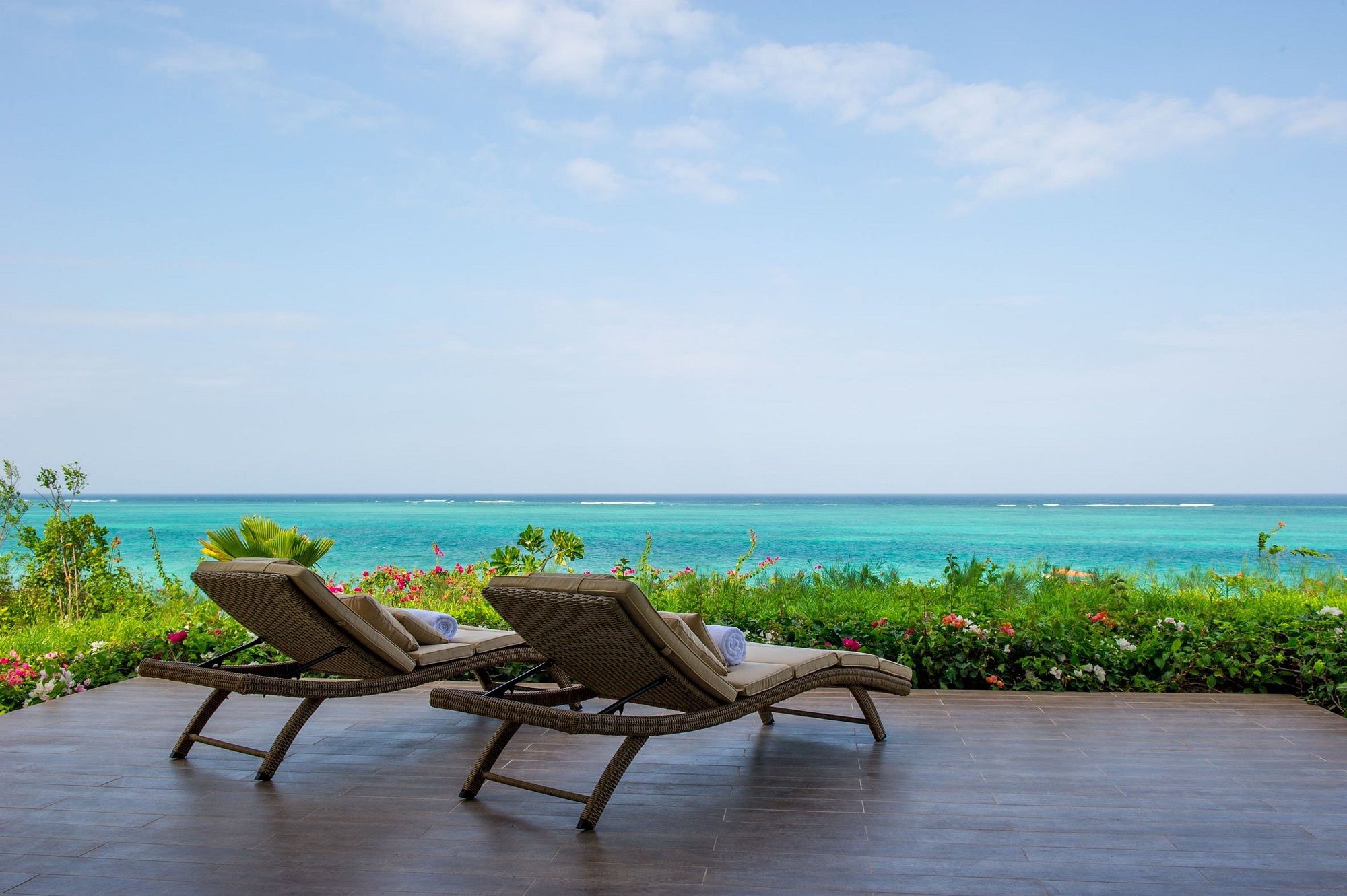 Terraza del Zawadi Hotel Zanzibar con tumbonas y vistas al mar
