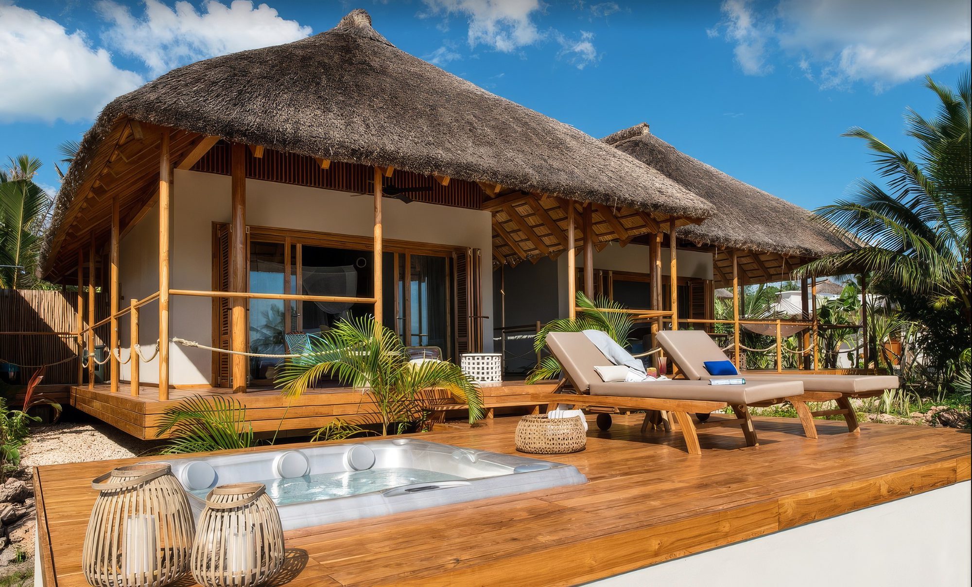 Bungalow mit Reetdach, Holzdeck mit Whirlpool und zwei Liegen bei der Lodge Zuri Zanzibar