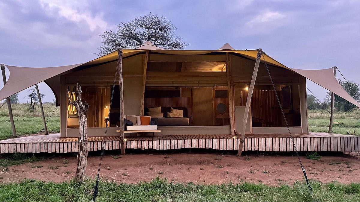Tienda de Anantya Serengeti sobre una plataforma de madera con velas de sombra y frente abierto