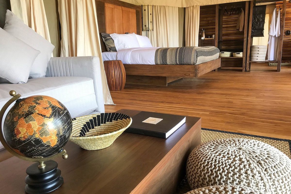 Habitación de la tienda en el Aurari Camp con sofá, globo terráqueo en la mesa de centro y cama