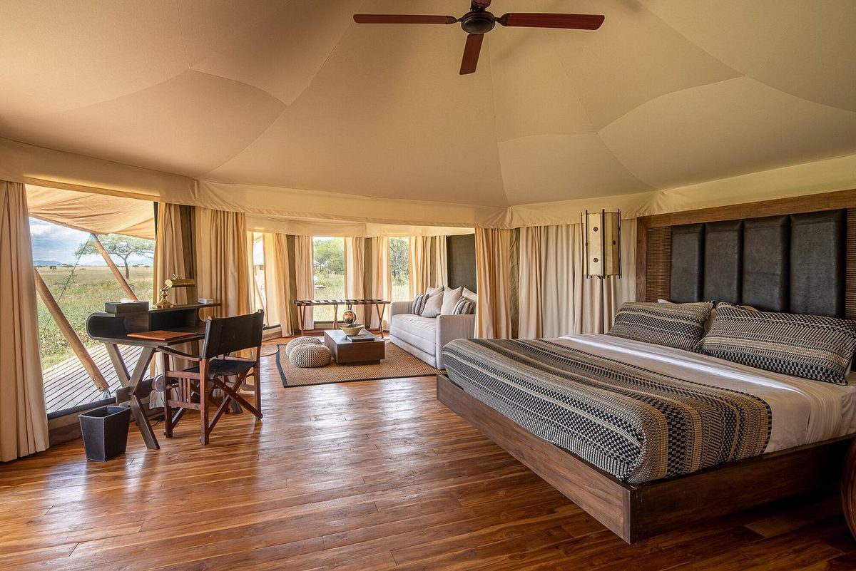 Geräumiges Zeltzimmer im Cherero Camp mit Bett, Holzboden und Blick in die Savanne