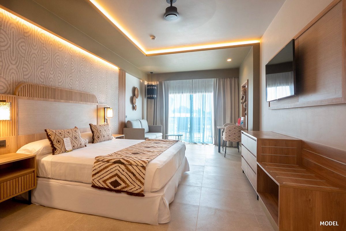 Habitación de hotel en el Hotel Riu Jambo con cama doble, zona de estar y ventana al balcón