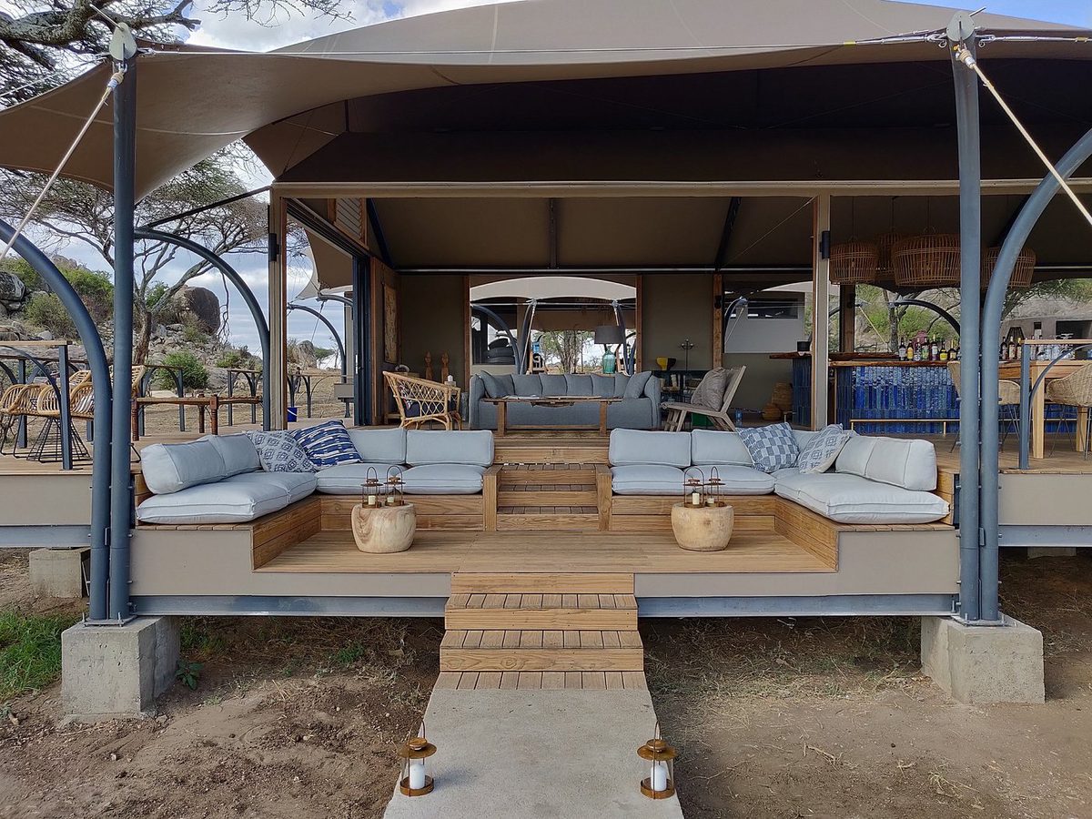 Terraza lounge de Lemala Nanyukie con sofás bajo un techo de tienda, rocas detrás