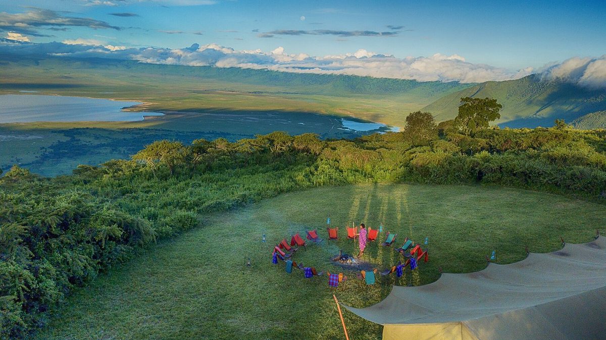 Feuerstelle des Pakulala Safari Camp mit bunten Stühlen im Kreis auf einer Wiese am Kraterrand