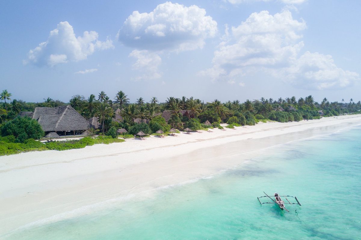 Vista aérea de la playa de arena del Zanzibar Pearl Boutique Hotel & Villas con mar turquesa y palmeras