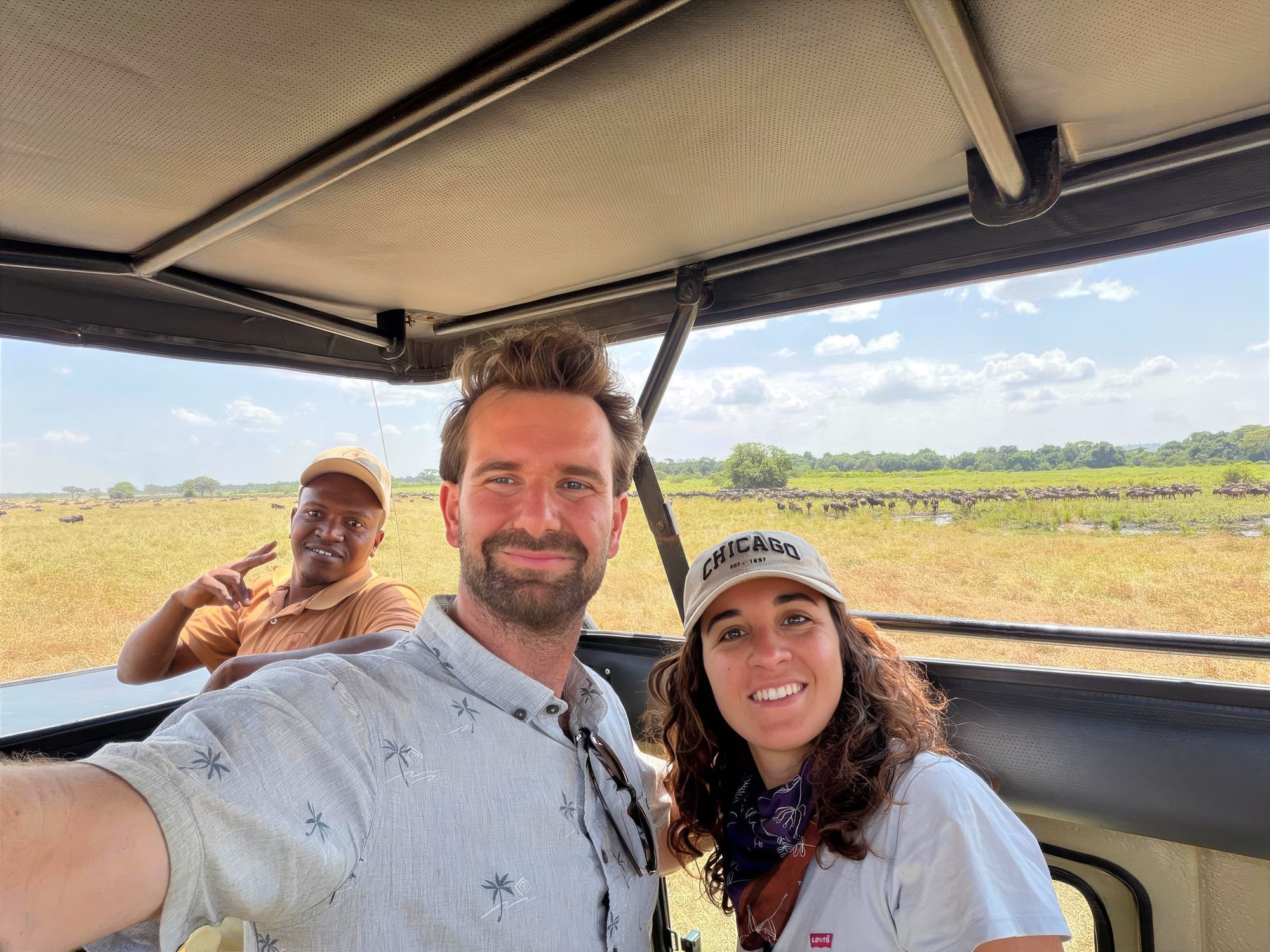 Guide und zwei Gäste machen ein Selfie im Safarifahrzeug